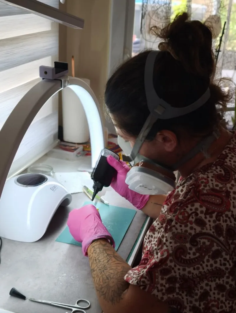 Amandine, créatrice de L’Atelier d’Emy‑Lys, en pleine fabrication de bijoux en fleurs séchées dans son atelier à Masseret (Corrèze)