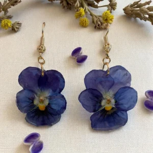 Boucles d’oreilles en résine avec fleurs de pensée bleutée, montées sur crochet doré – bijou floral délicat fait main