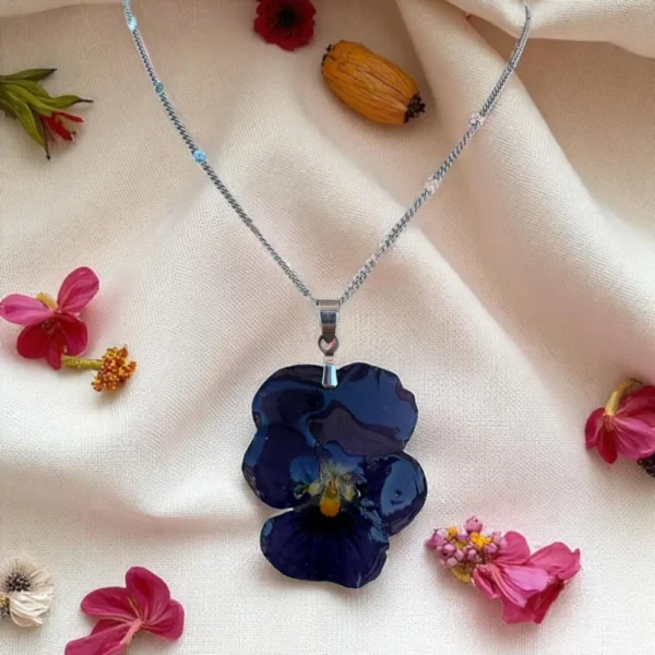 Collier en pensée naturelle violette montée sur chaîne argentée, bijou artisanal unique de L’Atelier d’Emy-Lys réalisé avec une vraie fleur stabilisée et résinée.