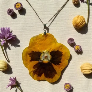 Pendentif floral jaune vif en forme de pensée, monté sur chaîne argentée, bijou fait main avec une véritable fleur naturelle résinée – L’Atelier d’Emy-Lys.