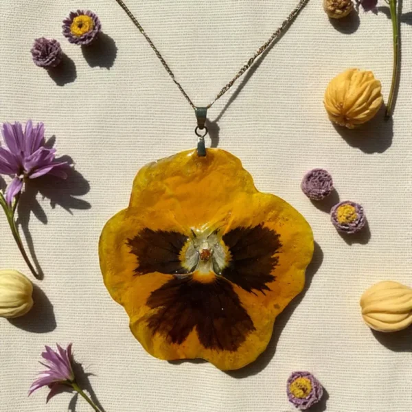 Pendentif floral jaune vif en forme de pensée, monté sur chaîne argentée, bijou fait main avec une véritable fleur naturelle résinée – L’Atelier d’Emy-Lys.