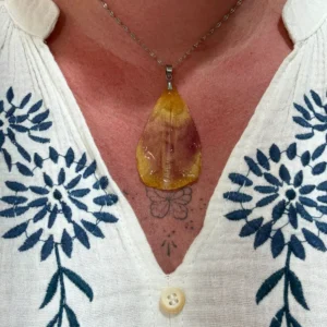 Collier artisanal en pétale de tulipe naturel jaune et bordeaux, monté sur chaîne argentée, porté sur peau, création florale de L’Atelier d’Emy-Lys.