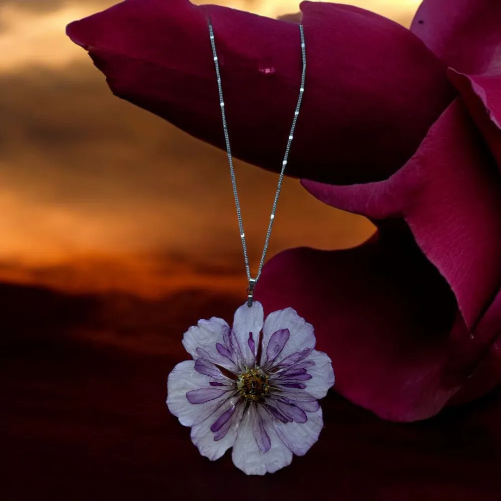 Collier argenté orné d’une fleur séchée blanche et violette, bijou floral artisanal unique – L’Atelier d’Emy‑Lys