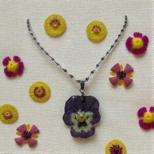 Collier argenté décoré d’une pensée séchée violet foncé – bijou floral fait main L’Atelier d’Emy‑Lys