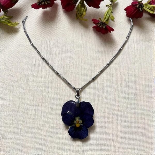 Collier argenté orné d’une pensée séchée bleu nuit – bijou artisanal unique L’Atelier d’Emy‑Lys