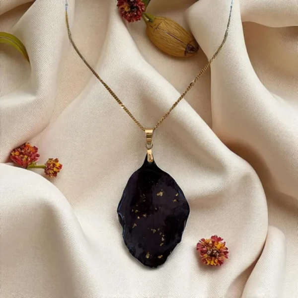 Collier doré orné d’un pétale de clématite séché avec éclats dorés, bijou artisanal unique – L’Atelier d’Emy‑Lys