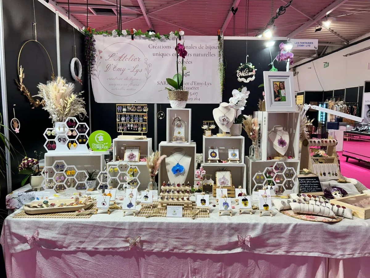 Stand de L’Atelier d’Emy‑Lys présentant des bijoux artisanaux en fleurs séchées sur un salon de créateurs