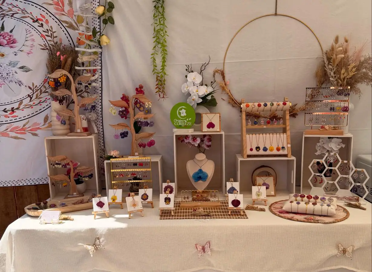 Stand de L’Atelier d’Emy‑Lys présentant des bijoux artisanaux en fleurs séchées sur un salon de créateurs